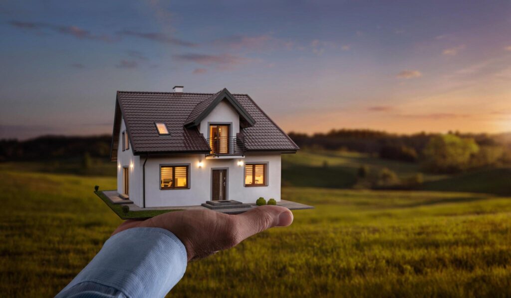 male-hand-showing-offering-a-new-dream-house-at-the-empty-field